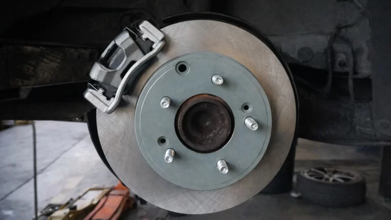 Disc brake system with brake rotor and caliper installed in an auto repair shop