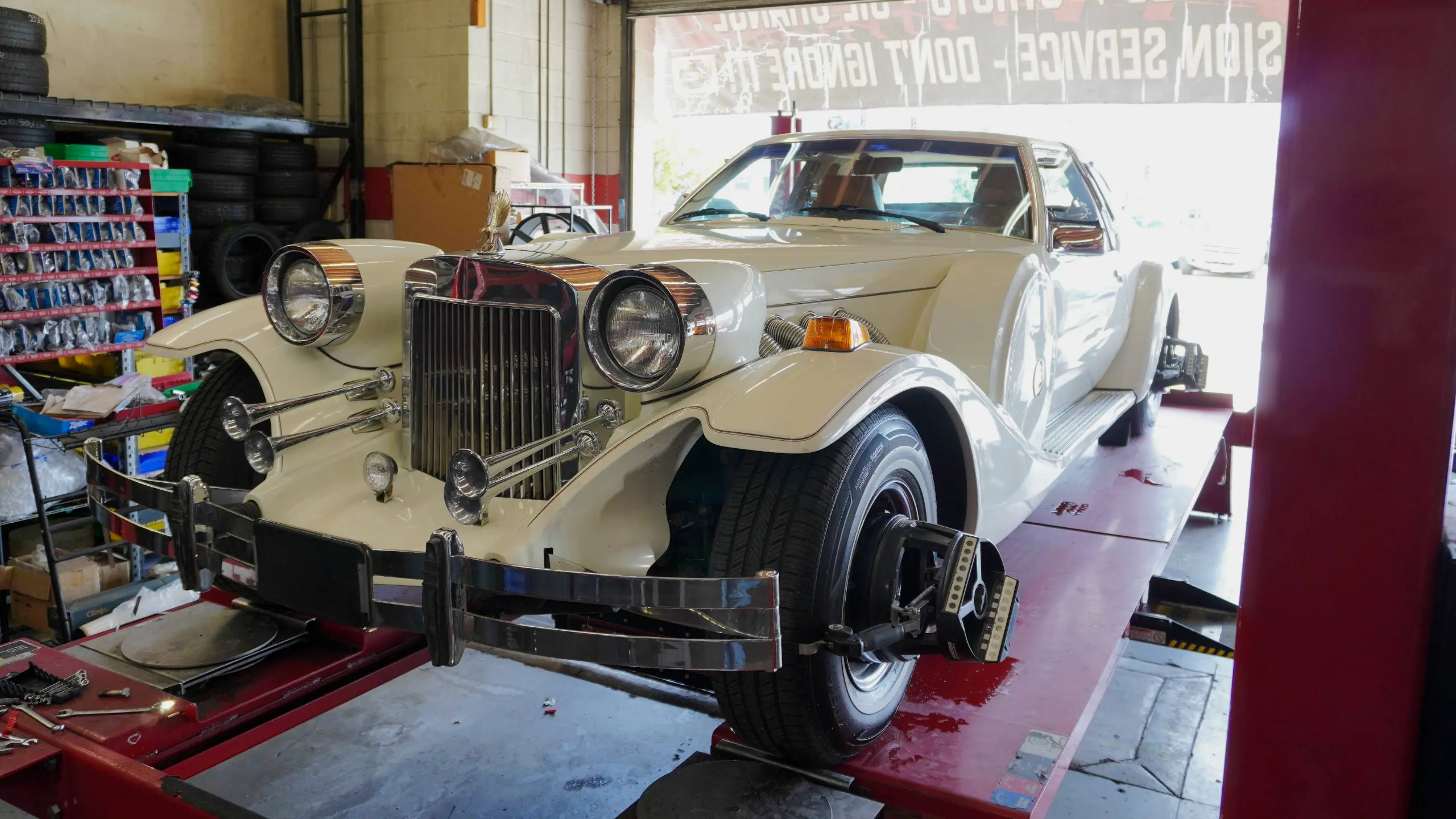 Classic car undergoing professional wheel alignment at a tire shop to improve handling and tire longevity 