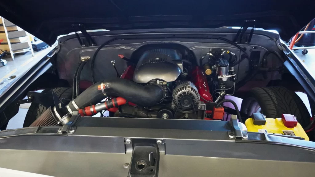 car engine with open hood showing air conditioning system components.webp