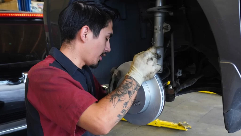 technician inspecting suspension during wheel alignment