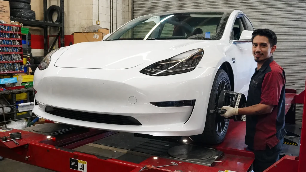 Technician checking wheel alignment and tire wear at Comtires