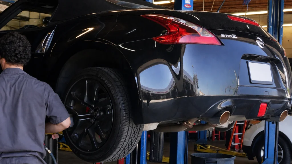 Technician inspecting a vehicle tire, alignment and suspension