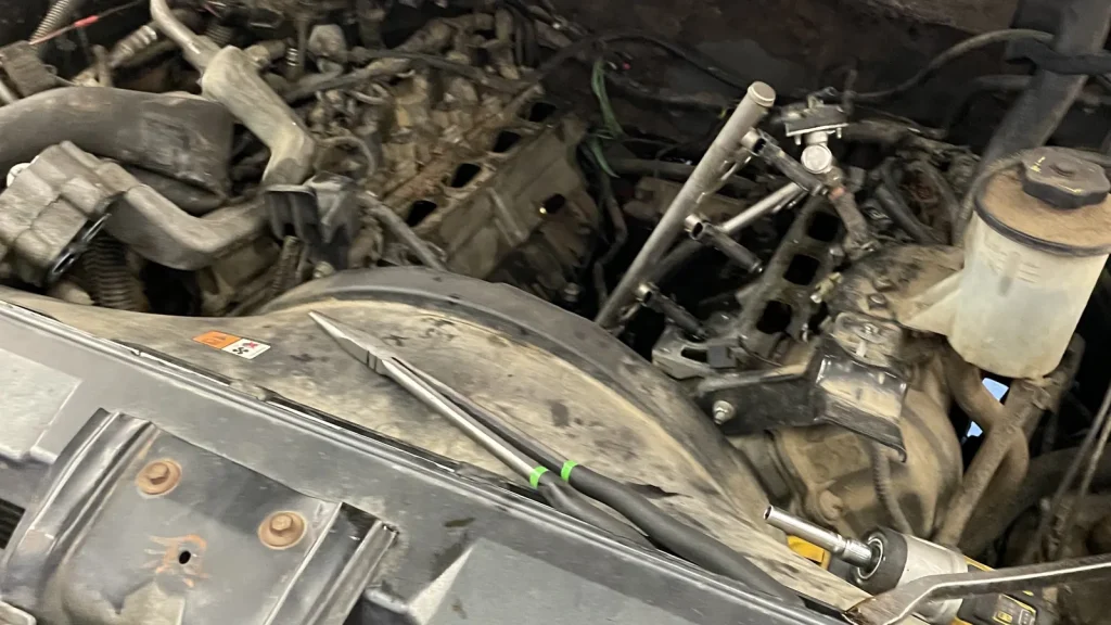 Engine bay with the front end removed for an A/C compressor repair at Comtires in Ontario, CA