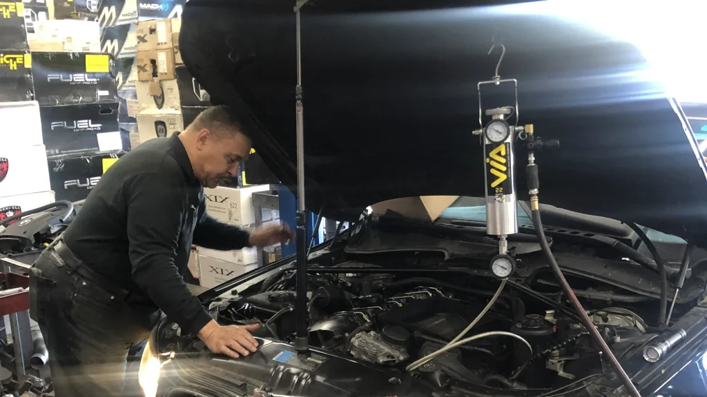 Technician running a fuel and air intake cleaning service on a BMW at Comtires in Ontario, CA
