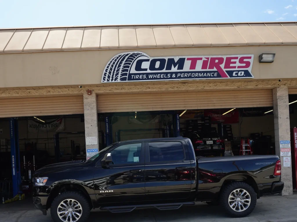 Comtires auto repair shop on Holt Blvd in Ontario, CA, with a black Ram pickup parked out front
